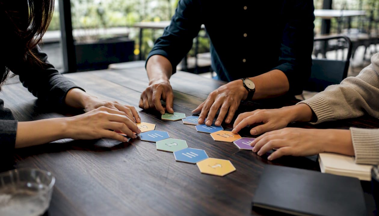 Hands arranging process mapping tiles collaboratively